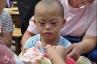 愛(ài)心人士在給孤殘兒童喂蛋糕